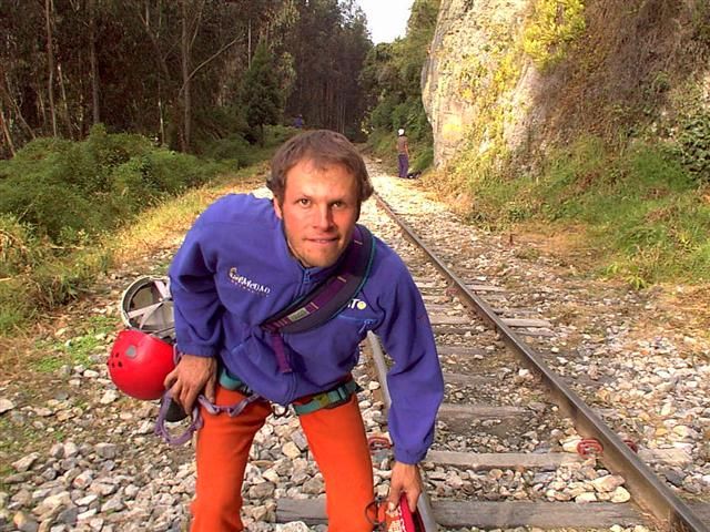 Escalador con su casco junto a la carrilera del tren en Suesca
